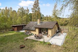 a small house with a patio in a yard at Lovely Summer Villa In Natural Surroundings in Rødby
