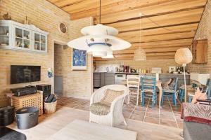 a kitchen and living room with a table and chairs at Lovely Summer Villa In Natural Surroundings in Rødby