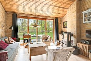 a living room with a couch and a tv at Lovely Summer Villa In Natural Surroundings in Rødby