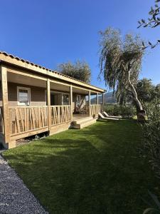 a house with a porch and a grass yard at Les collines de lava in Appietto