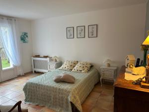 una camera da letto con un letto, un tavolo e una finestra di La vie en rose sur le Larzac a La Vacquerie-et-Saint-Martin-de-Castries