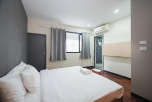 Un dormitorio con una cama blanca y una ventana. en XX GO INN Silom - BTS Saint Louis โกอินน์ สีลม - สถานีรถไฟฟ้าเซนต์หลุยส์, en Yan Nawa