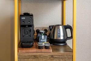 a coffeemaker and a coffee maker on a shelf at Hotel Die Port van Cleve in Amsterdam