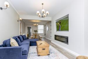 a living room with a blue couch and a fireplace at Eller Cottage in Windermere