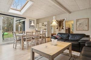 un soggiorno con un divano e un tavolo di Cozy Cottage Near Limfjorden a Roslev