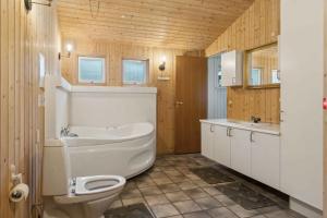 un bagno con vasca, WC e lavandino di Cozy Cottage Near Limfjorden a Roslev