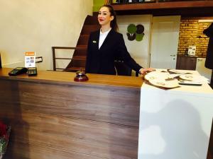 リド・ディ・オスティアにあるAppartamento Levanteの店のカウンターに立つ女