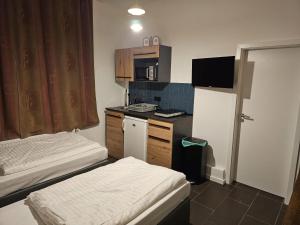 a small kitchen with two beds and a refrigerator at ApartHotel Slumber in Geesthacht