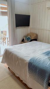 a bedroom with a large bed and a window at Casa da lagoa Doce!! in Imbituba +2 photos