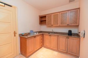 a kitchen with wooden cabinets and a sink at Sheraton Soma Bay Resort in Hurghada