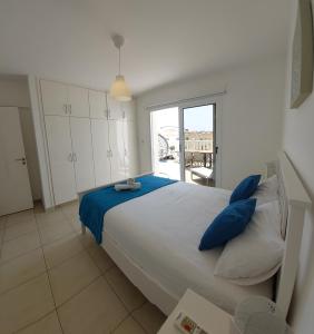 a bedroom with a large bed with blue pillows at Nissi Retreat - Walk to Nissi beach! in Ayia Napa