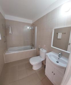 a bathroom with a toilet and a tub and a sink at Nissi Retreat - Walk to Nissi beach! in Ayia Napa +22 photos