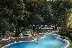 una piscina con due persone in acqua di ZANA Luxury Suites and Cottages, Dhikuli, Jim Corbett a Ramnagar Altre 36 foto