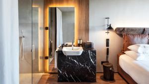 a bathroom with a sink and a bed and a mirror at Puro Dão Hotel & Spa in Nelas
