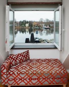 a window with a bed and a view of a river at Hotel Altes Fährhaus in Berlin