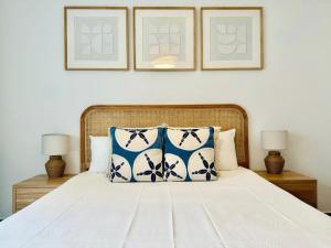 a bedroom with a bed with blue and white pillows at Canaryislandshost l Girasol in Punta de Mujeres