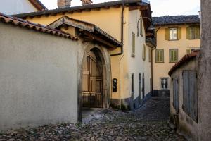 an alleyway in an old building with a gate at La Corte Moderna nel centro storico - idromassaggio in Clusone