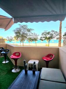 ラス・アル・ハイマにあるSeaview Escape Family Two-Room Apartment with Seaviewのビーチを望む椅子とテーブル付きの客室です。