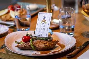 a plate with a piece of meat on a table at Hotel Die Port van Cleve in Amsterdam