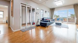 a living room with a leather couch and a large window at Jeju Jongdal Private Pension in Jeju +1 photo