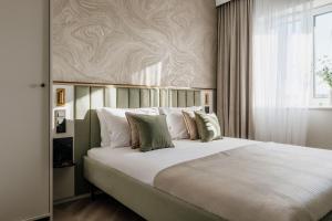 a bedroom with a large bed with white sheets and pillows at Millou - LoftAffair Collection in Kraków