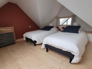 a attic bedroom with two beds and a window at La grange de Rose et François in Le Conquet