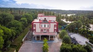 an overhead view of a red building with a balcony at Sakthi River Resort in Pollāchi