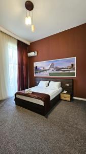 a bedroom with a large bed with a large painting on the wall at ELYSIUM HOTEL in Baku