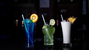 three cocktails sitting on a table with at Sakthi River Resort in Pollāchi