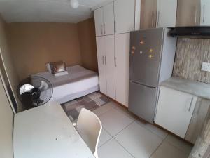 a small kitchen with a refrigerator and a chair in it at 54 Malcolm Hidden Gem near Musgrave in Durban