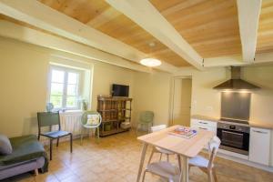 une cuisine et un salon avec une table et des chaises dans l'établissement La maison de mamie, à Allemans