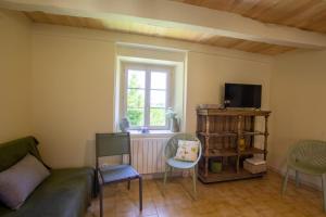 un salon avec un canapé, des chaises et une fenêtre dans l'établissement La maison de mamie, à Allemans