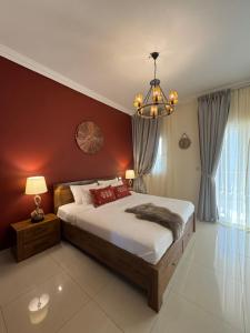a bedroom with a large bed and a chandelier at Western Townhouse with swimming pool in Ras al Khaimah +13 photos