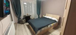 奥内什蒂Studio Ultracentral cu balcon的一间带床和电视的小卧室