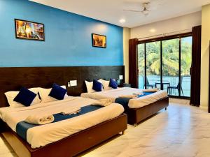 two beds in a room with blue walls at Golden Pearl Resort By Gemstone Hospitality in Alibag +37 photos