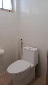 a white toilet in a bathroom with a window at Koh Mook Sivalai Beach Resort in Ko Mook