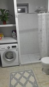 a bathroom with a washing machine and a toilet at Kairat guest house in Kashkaldak
