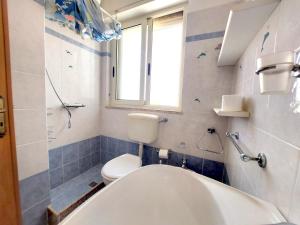 bagno con vasca, servizi igienici e finestra di Bellissimo attico a 70 mt dalla spiaggia a Torre Pali Altre 31 foto
