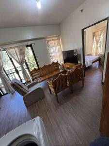 ein Wohnzimmer mit Stühlen, einem Tisch und einem Bett in der Unterkunft Outlook Ridge Residences VY in Baguio City