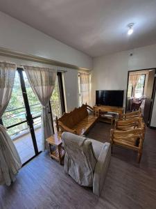 ein Wohnzimmer mit Sofa und Fernseher in der Unterkunft Outlook Ridge Residences VY in Baguio City