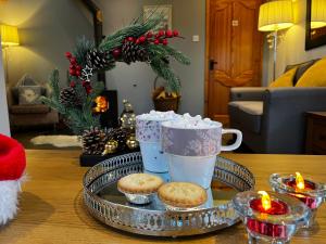 a tray of cookies and cups on a table with candles at Ty Efail Cottage mountain views & secure garden in Beaumaris +37 photos