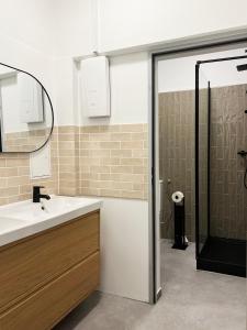 Un baño con lavabo, espejo y ducha. en Modern Design 75sq Apartment in Berlin Mitte, en Berlín