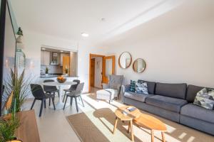 een woonkamer met een bank en een tafel bij Bay View T1 - By Smarthomes in São Martinho do Porto