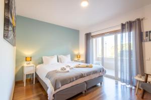 een slaapkamer met een bed en een groot raam bij Bay View T1 - By Smarthomes in São Martinho do Porto +26 foto's