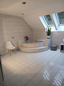 a bathroom with a tub and a chair in it at Dom blisko lotniska i Areny Tarczyńskiego in Wrocław +17 photos