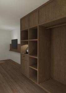 a wooden book shelf with a tv in a room at Bryggjan Boutique Hotel in Akureyri +5 photos