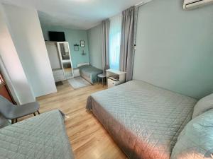 a hotel room with two beds and a chair at House Varna-3 in Krapets