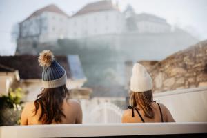 two women sitting on a bench looking at a waterfall at FRIDA Apartman, Exkluzív várpanorámával, a belváros szívében, ingyenes parkolással in Veszprém +28 photos