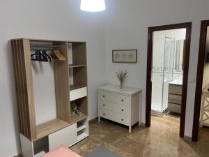 a room with a cabinet and a dresser and a mirror at Apartamento Cerezo in Carmona