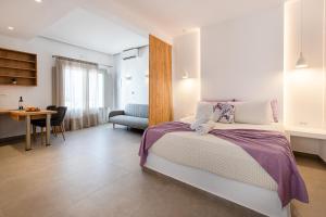 a bedroom with a bed and a table and a chair at Santorini Villatzio Suites in Mesaria +58 photos